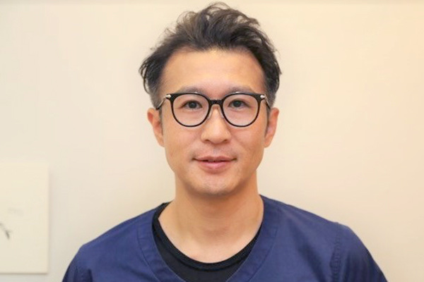黒縁眼鏡をかけて正面を向く矯正担当の高田竜一郎